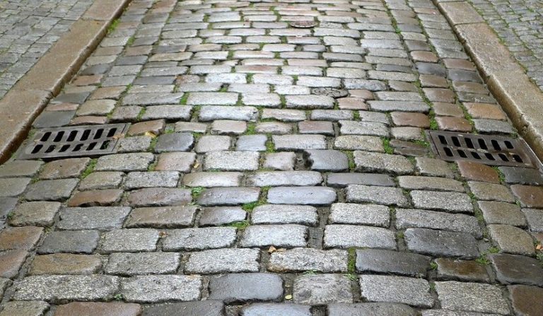 Caduta sulla strada causata da sampietrini mancanti