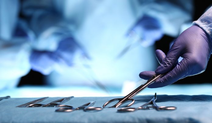 Nurse,Hand,Taking,Surgical,Instrument,For,Group,Of,Surgeons,At Ipertermia maligna nel corso di intervento di riduzione della frattura