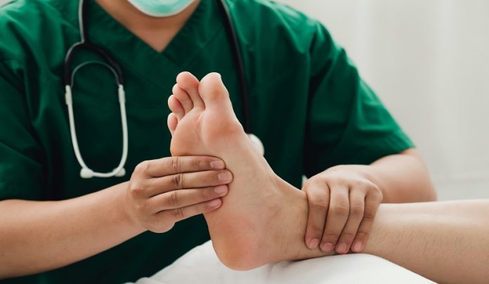 Consultation,Physiotherapist,With,The,Treatment,Of,Treating,Injured,Ankle,Pain Trattamenti fisioterapici post infortunio ritenuti abnormi