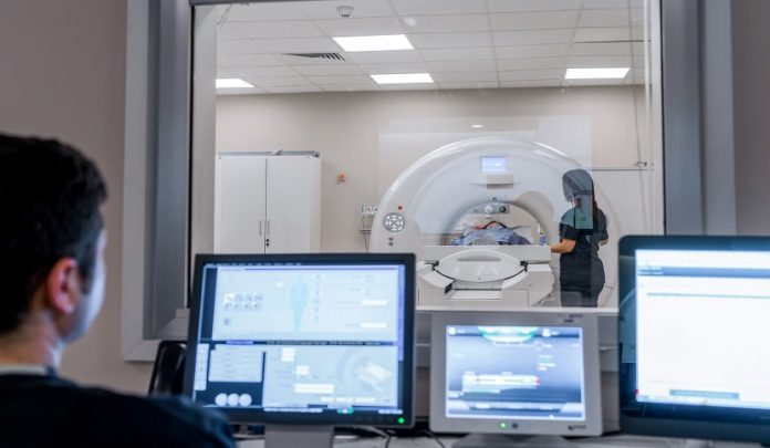 The,Radiology,Technician,In,The,Cabin,Stands,Next,To,His Assorbimento di radiazioni ionizzanti del tecnico radiologo