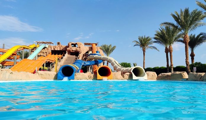 Water,Park,With,Colorful,Slides,And,Pools.,Water,Slides,And Trauma cranico riportato sullo scivolo del parco acquativo