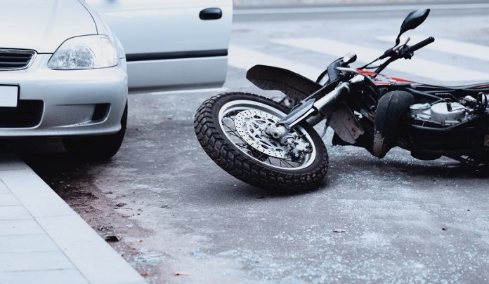 Motorcycle,Lying,On,The,Road,And,Car,Standing,With,Open Apertura della portiera del veicolo provoca la caduta della moto