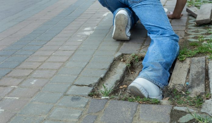 Lastra del marciapiede spezzata e avvallata provoca lesioni