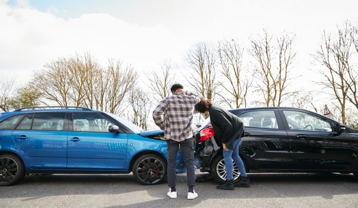 Young,Male,And,Female,Drivers,Looking,At,Damaged,Car,Hit Tamponamento al semaforo e presunzione di pari responsabilità