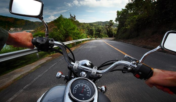 Rider,Driving,Motorcycle,On,A,Rural,Road,In,A,Mountains Manovra imprudente della moto sbalza a terra la trasportata